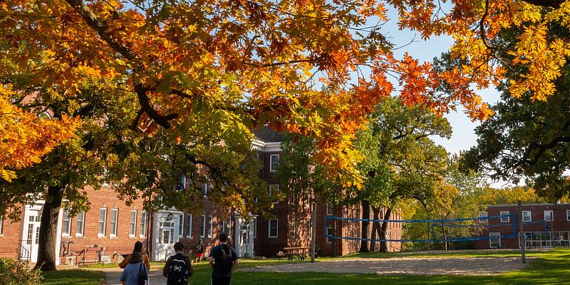 Students walk together to class under the colorful leaves of Beloit’s campus in autumn.